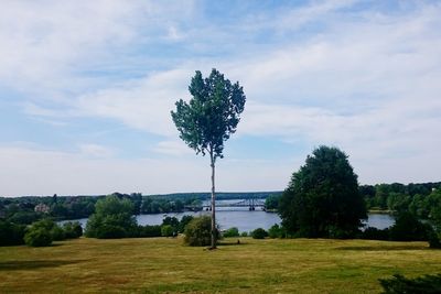 Scenic view of river against cloudy sky