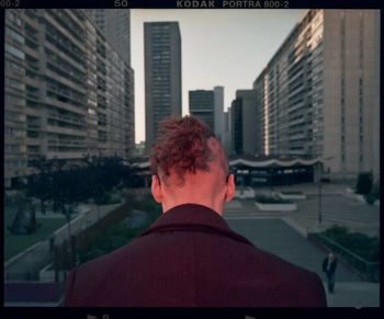 Rear view of man looking at city buildings