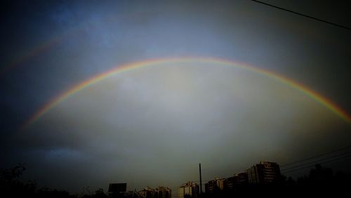 Rainbow over trees against sky