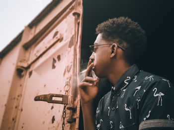 Side view of young man looking at camera