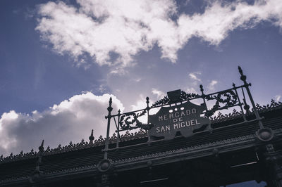 Low angle view of text on roof against sky