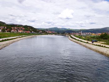 Bridge over river against sky in city