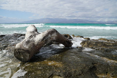 Rocks in sea against sky