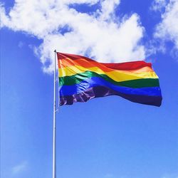 Low angle view of flag against blue sky