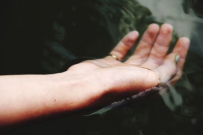 Cropped image of woman hand floating on lake