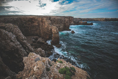 Rock formations by sea against sky