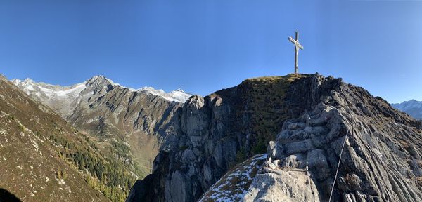 Low angle view of rocky mountains against blue sky