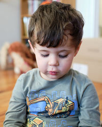 Portrait of a young boy of three playing with a toy in the living room