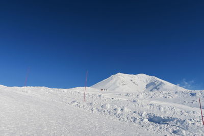 Scenic view of snowcapped mountains against clear blue sky