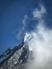 Low angle view of snowcapped mountain against sky