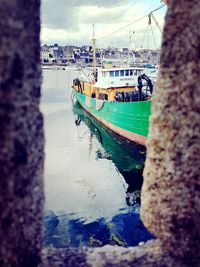 Boats moored at harbor against sky