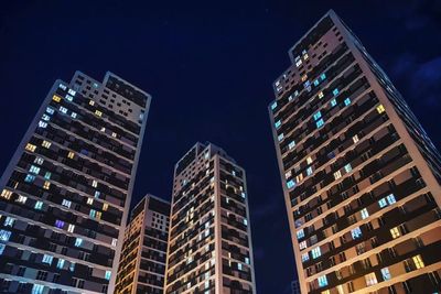 Low angle view of illuminated buildings against sky at night