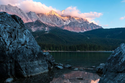 Scenic view of lake by mountains against sky