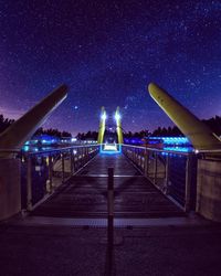 Illuminated bridge against sky at night