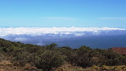 Scenic view of sea and mountains against blue sky