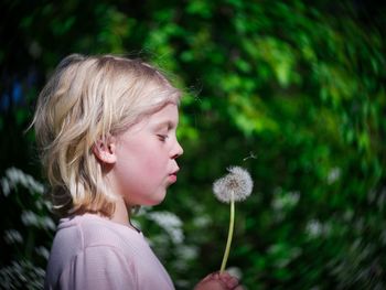 Close-up of girl with flowers against blurred background