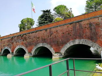 Arch bridge over river against sky