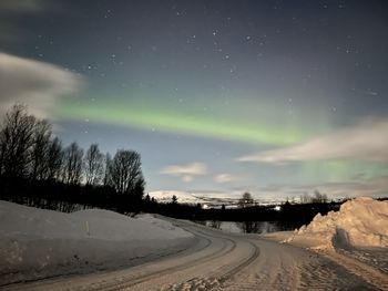 Road against sky at night during winter