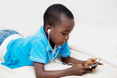 Rear view of boy using mobile phone