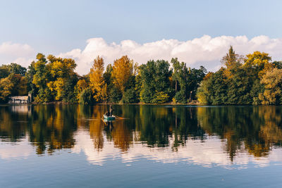 Reflection of trees in calm lake against sky