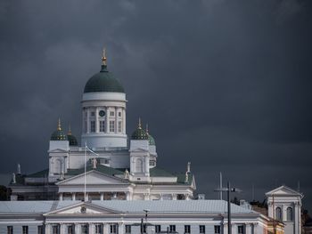 Buildings in city against cloudy sky