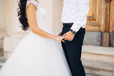 Rear view of couple holding hands