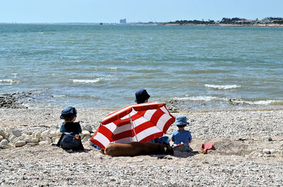 Rear view of people sitting on beach