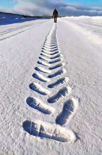 View of tire tracks on snow covered land