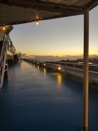 Illuminated bridge over sea against sky during sunset