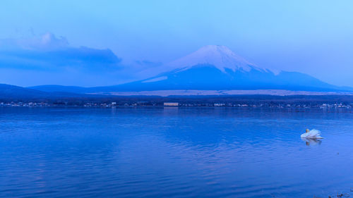 Scenic view of sea and snowcapped fuji mountains reflections and blue sky in japan 