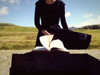 Woman with arms raised against sky