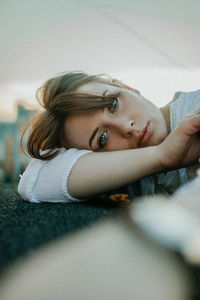 Portrait of young woman lying on bed