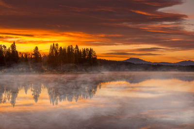 Scenic view of lake against orange sky