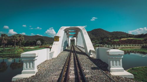 Railroad tracks by mountain against sky
