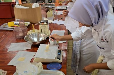 People working on table in kitchen