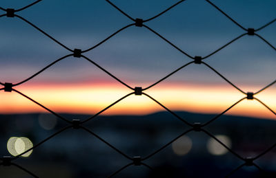 Chainlink fence against sky at dusk