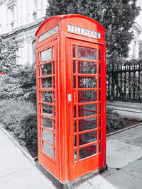 Red telephone booth on street in winter