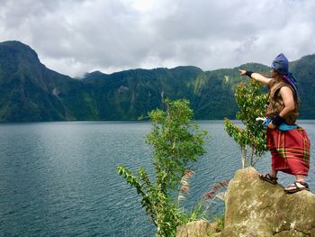 Side view of a man standing by lake