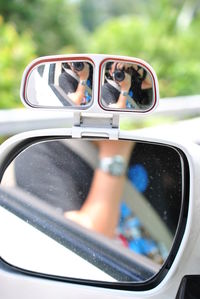 Close-up of sunglasses on side-view mirror