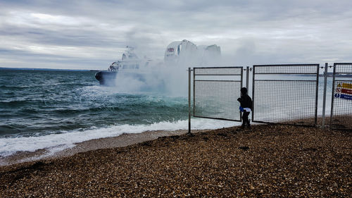 Man standing on beach by sea against sky