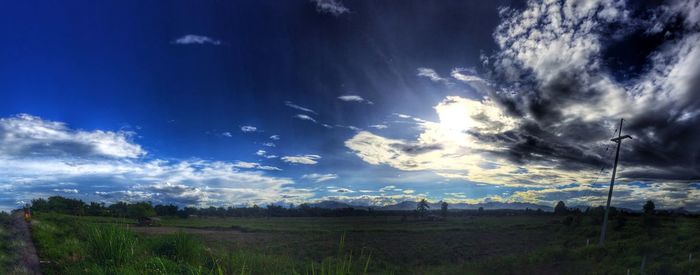 Scenic view of grassy field against cloudy sky