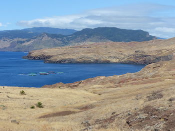 Scenic view of sea and mountains against sky