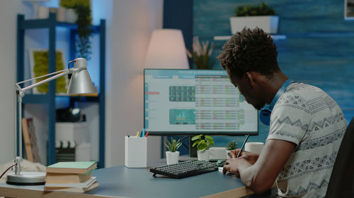 Side view of man using laptop at office