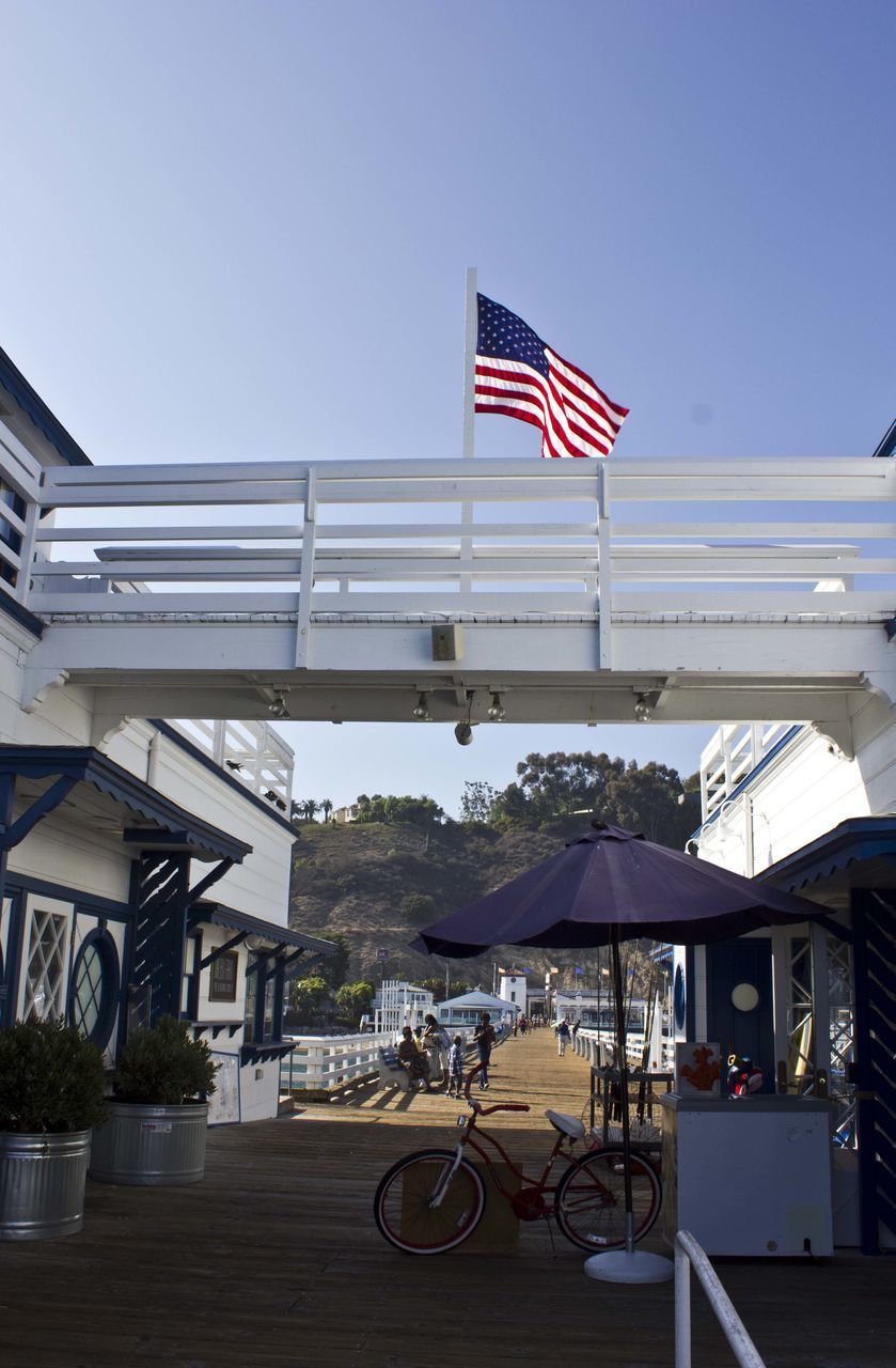 FLAG BY BUILDING AGAINST CLEAR SKY