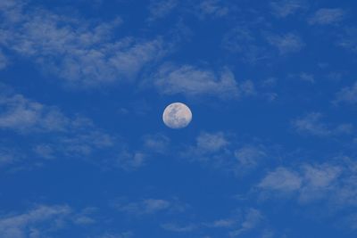 Low angle view of moon against blue sky