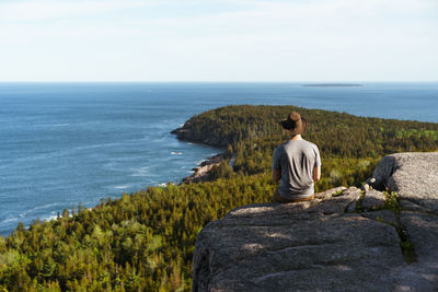 Man viewing otter cliff from gorham mountain, acadia national park, maine, usa