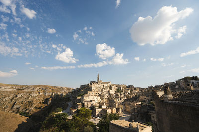 Buildings in city against cloudy sky