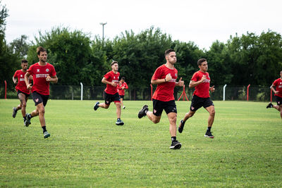 Group of people running on soccer field