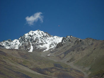 Scenic view of snowcapped mountains against blue sky