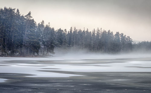 Scenic view of lake against sky during winter